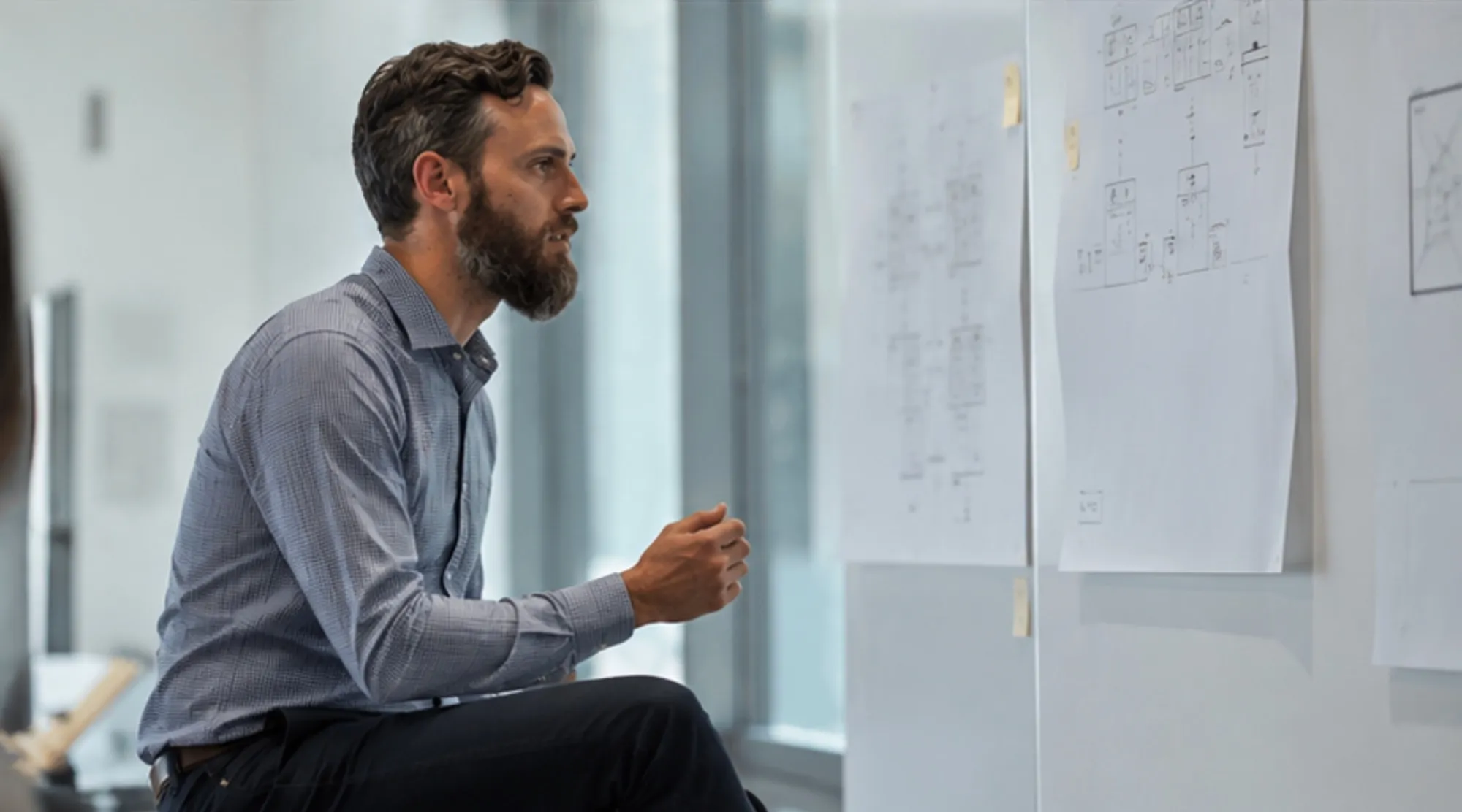 A NimbleBrain engineer working through a wall of printed process diagrams